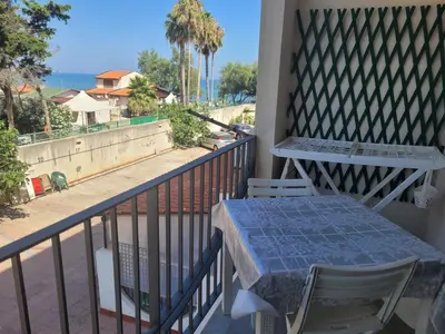 a table and chairs on a balcony with a view of the ocean at Bilocale Lungomare Carini in Carini