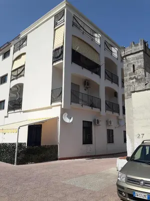 a white building with a car parked in front of it at Bilocale Lungomare Carini in Carini