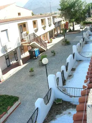 a row of white benches in a courtyard at Bilocale Lungomare Carini in Carini