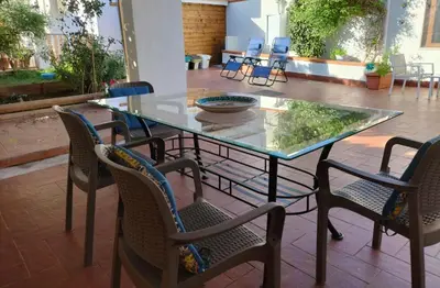 a glass table and chairs in a patio at Green Space Apartment in Mondello