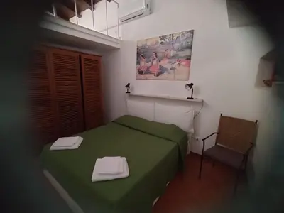 a bedroom with a green bed and a chair at Green Space Apartment in Mondello