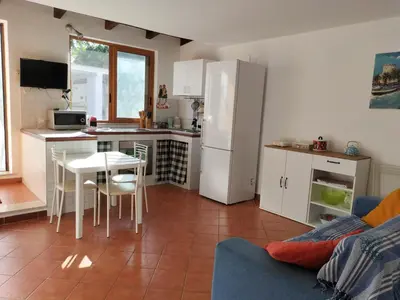 a kitchen with a table and a white refrigerator at Green Space Apartment in Mondello