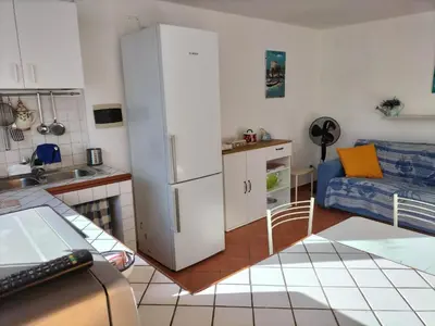 a kitchen and living room with a white refrigerator at Green Space Apartment in Mondello