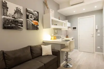 a living room with a couch and a desk and a kitchen at Palermo ai Leoni in Palermo