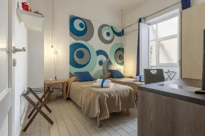 a small room with two beds and a window at MassimoCentro Rooms in Palermo