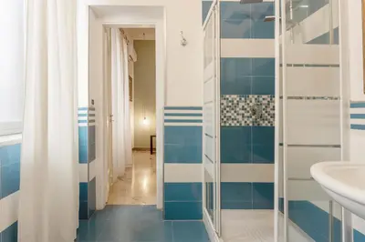 a bathroom with blue and white tiled walls at MassimoCentro Rooms in Palermo