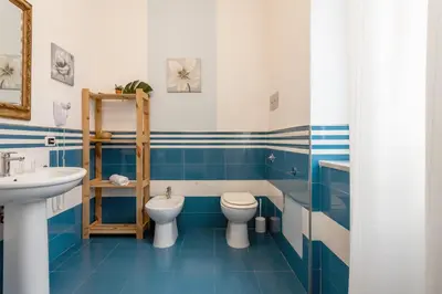 a blue and white bathroom with a toilet and a sink at MassimoCentro Rooms in Palermo