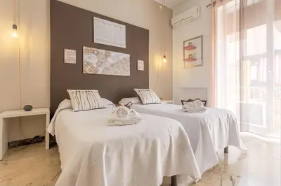 two beds sitting next to each other in a room at MassimoCentro Rooms in Palermo