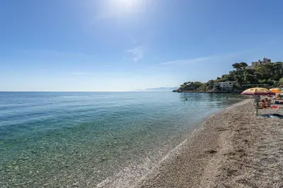 a sandy beach with umbrellas and the ocean at Dimore di mare - Beachfront Apartments in Santa Flavia