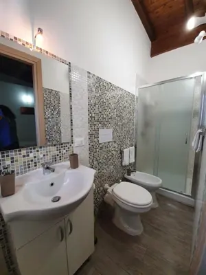 a bathroom with a sink and a toilet and a shower at Arricàmpati Airport Rooms & Bringo Car Rental in Carini