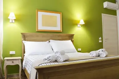 a green bedroom with a bed with towels on it at Piazza Marina in Palermo