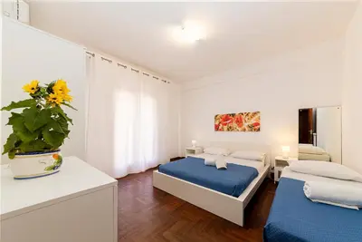 a bedroom with two beds and a vase with a plant at Maison Blanche in Palermo