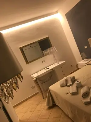 a bedroom with a bed and a desk and a mirror at B&B Timpe Bianche in Castelluzzo