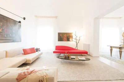 a white living room with a red couch at Gattopardo Apartments - LAGO Design by Wonderful Italy in Palermo