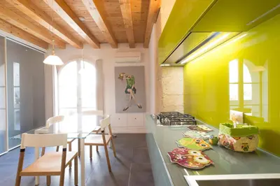 a kitchen with a green counter top and a table at Gattopardo Apartments - LAGO Design by Wonderful Italy in Palermo