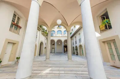 an empty hallway of a building with columns at Gattopardo Apartments - LAGO Design by Wonderful Italy in Palermo