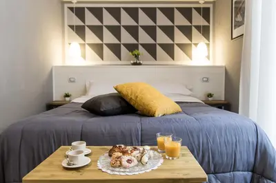 a bed with a table with a tray of food on it at Balate Maqueda B&B in Palermo