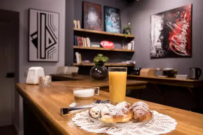 a table with a plate of pastries and a glass of orange juice at Balate Maqueda B&B in Palermo