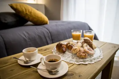 a coffee table with two cups of coffee and pastries at Balate Maqueda B&B in Palermo