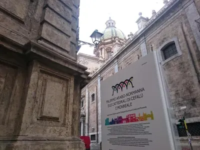 a sign in front of a building with a tower at Balate Maqueda B&B in Palermo