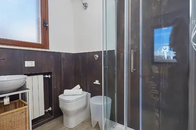 a bathroom with a toilet and a glass shower at Villa Tarì in Scopello