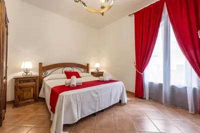 a bedroom with a large bed with red curtains at Hotel Castello di Giuliano in Montelepre