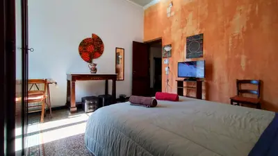 a bedroom with a bed and a table and a television at Appartamenti Olivuzza in Palermo