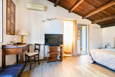 a bedroom with a bed and a desk and a television at Appartamenti Olivuzza in Palermo