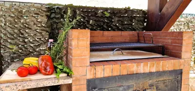 a brick barbecue with vegetables on a cutting board at Villa Paradiso in Alcamo Marina