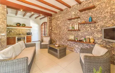 a living room with couches and a tv on a stone wall at Villa Belvedere in Sambuca di Sicilia