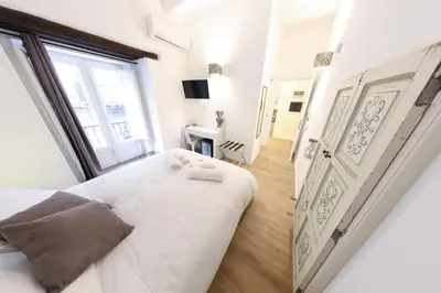 a white bedroom with a large bed and a window at Bedda Mari Rooms & Suite in Palermo