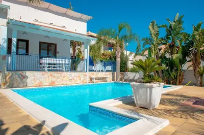 a swimming pool in front of a house at Villa Oleandro in Alcamo Marina