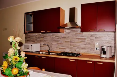 a kitchen with red cabinets and a counter top at B&B Federico II in San Cipirello