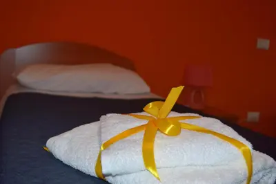 a white towel with a yellow ribbon on a bed at B&B Federico II in San Cipirello