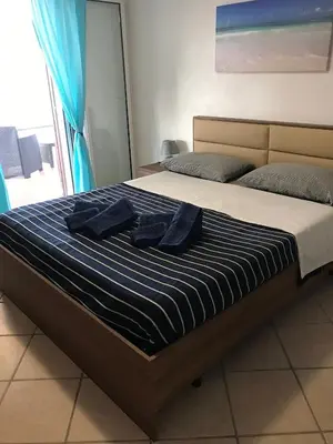 a bed with two blue towels on top of it at Le Terrazze sul Mare - Capo Aranciotto Beach in Cefalù