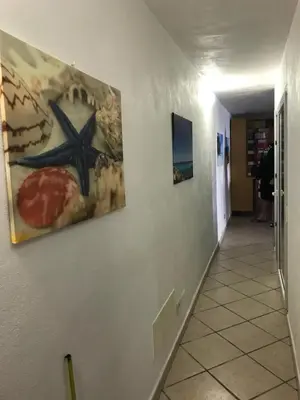 a hallway with a painting on a white wall at Le Terrazze sul Mare - Capo Aranciotto Beach in Cefalù