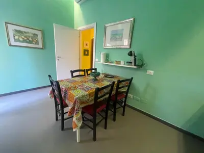 a dining room with a table and chairs and a yellow door at Belmonte Blu Suite in Palermo