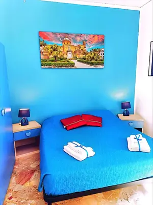 a blue bedroom with a bed with two towels on it at B&B D'Amico87 in Bagheria