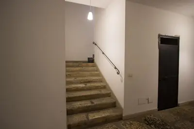 a hallway with a column and a wooden door at L'Atelier Dei Quattro Canti in Palermo