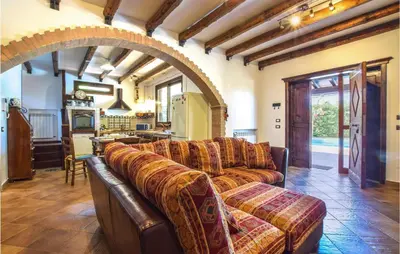 a living room with a couch and a kitchen at Villa Tourig Beach in Mandra Capreria