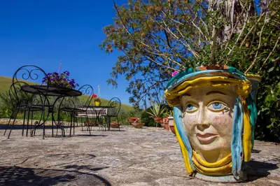 a statue of a head is sitting next to a table at Agriturismo Tarantola in Alcamo