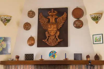 a wooden crest on a wall with candles on a shelf at Agriturismo Tarantola in Alcamo