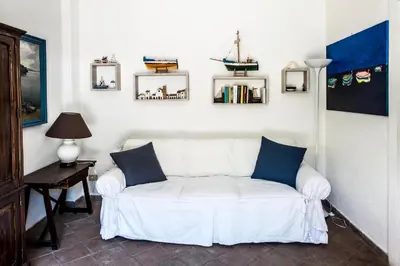 a white couch with blue pillows sitting in a living room at Ciuri Ciuri Mondello in Mondello