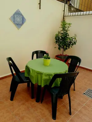 a green table with four chairs and a potted plant at Rabbad Apartments in Palermo