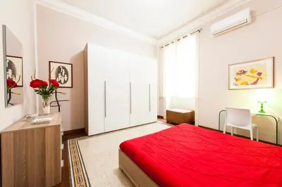 a bedroom with a red bed and a white door at Rabbad Apartments in Palermo