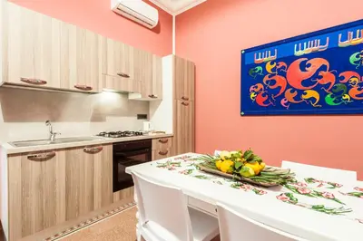 a kitchen with pink walls and a white table and chairs at Rabbad Apartments in Palermo