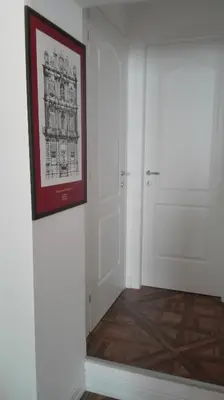 a hallway with a white door and a picture on the wall at Demetra Rooms in Palermo