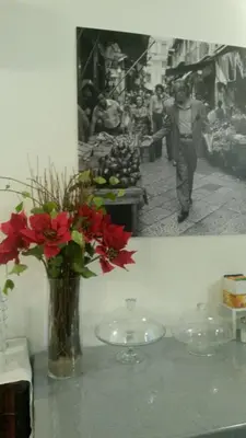 a vase with red flowers sitting on a table at Demetra Rooms in Palermo
