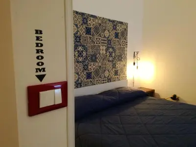 a bedroom with a bed and a sign on the wall at Le Luminarie - Creative Residence in Balestrate