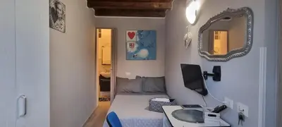 a small room with a bed and a mirror at A Casa Di Lilly in Palermo
